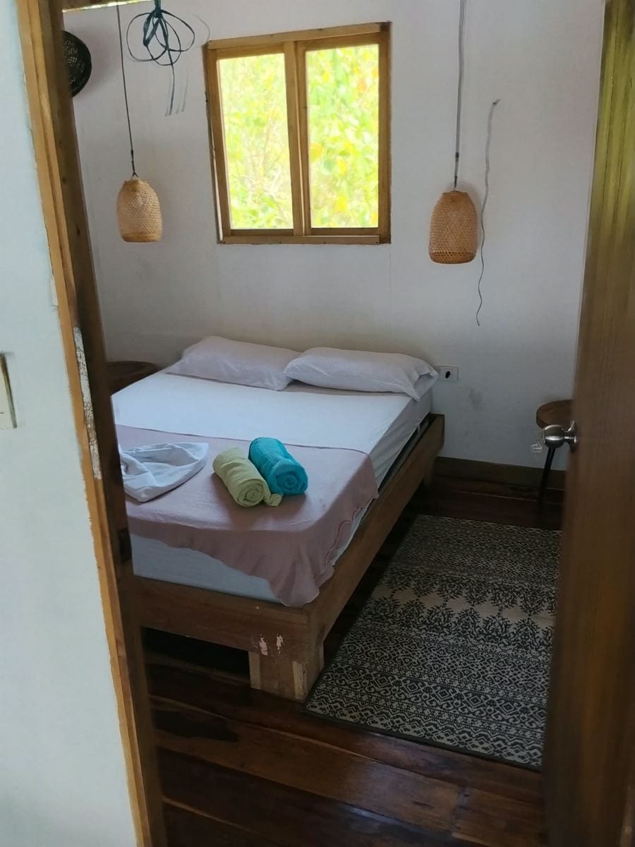 Cama doble de la habitación Sol con ventana a la terraza